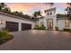 Charming home featuring a three-car garage, an inviting double door entrance, and brick paved driveway at 7532 Greystone St, Lakewood Ranch, FL 34202