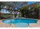 Sparkling pool with waterfall feature and scenic views of the golf course and lake at 7532 Greystone St, Lakewood Ranch, FL 34202