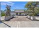 Inviting art center entrance featuring modern sculpture, manicured planters, and red brick walkway at 7620 Westmoreland Dr, Sarasota, FL 34243