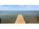 Wooden dock extending into clear, calm waters, providing a picturesque waterfront view, with clear skies at 7620 Westmoreland Dr, Sarasota, FL 34243