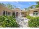 Front entrance to the home featuring a courtyard with fountain and mature landscaping at 7620 Westmoreland Dr, Sarasota, FL 34243