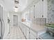 Well-lit kitchen with white cabinets, appliances, and long countertops at 7620 Westmoreland Dr, Sarasota, FL 34243