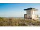 Picturesque beach scene with a lifeguard stand overlooking dunes and the ocean on a clear day at 7620 Westmoreland Dr, Sarasota, FL 34243