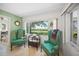 Cozy sitting area with two teal chairs, a table, and a view of the yard and water at 7620 Westmoreland Dr, Sarasota, FL 34243