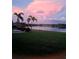 Tranquil backyard features lush greenery, a serene lake, and a beautiful pink sunset at 7743 Ridgelake Cir, Bradenton, FL 34203