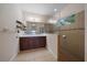 Modern bathroom with a double vanity, a large mirror, and a walk-in shower with glass enclosure at 7743 Ridgelake Cir, Bradenton, FL 34203