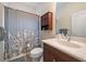 Bathroom with shower/tub combo, vanity with a wood cabinet and a decorative floral curtain at 7743 Ridgelake Cir, Bradenton, FL 34203