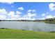 Scenic lake view with lush green grass in the foreground and residential community in the distance at 7743 Ridgelake Cir, Bradenton, FL 34203