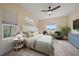 Spacious primary bedroom with a comfortable bed, large windows and green accent chairs at 7743 Ridgelake Cir, Bradenton, FL 34203