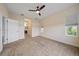 Carpeted main bedroom featuring an ensuite bathroom, ceiling fan, and a window at 7743 Ridgelake Cir, Bradenton, FL 34203