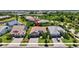 Aerial view of the property showcasing lush landscaping, a paver driveway, and a three-car garage at 8033 Grande Shores Dr, Sarasota, FL 34240