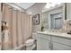 This bathroom features a shower with a curtain, a white vanity and neutral walls at 8033 Grande Shores Dr, Sarasota, FL 34240