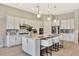 Modern kitchen with white cabinetry, stainless steel appliances, and a large island with bar seating and stylish pendant lighting at 8033 Grande Shores Dr, Sarasota, FL 34240
