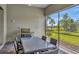 This is a covered patio with a table and chairs set and a grill at 8033 Grande Shores Dr, Sarasota, FL 34240