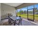 This is a covered patio with a stone floor and a table, chairs and grill at 8033 Grande Shores Dr, Sarasota, FL 34240