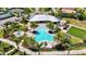 Aerial view of a community pool surrounded by palm trees and a clubhouse, offering a resort-style amenity at 8033 Grande Shores Dr, Sarasota, FL 34240