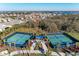 Aerial view of the community tennis courts, featuring well-maintained courts, landscaping, and ample parking at 8059 Waterbend Trl, Sarasota, FL 34240
