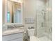 Bright bathroom featuring tiled glass shower, with coastal decor and modern vanity at 8059 Waterbend Trl, Sarasota, FL 34240