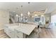 Bright kitchen with island seating, farmhouse sink, and views of the living room and outdoor space at 8059 Waterbend Trl, Sarasota, FL 34240