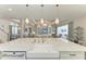 Open concept kitchen with large island, farmhouse sink and designer lighting overlooking the living room at 8059 Waterbend Trl, Sarasota, FL 34240