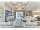 Bright living room with coffered ceilings, stylish furnishings, and sliding doors to the lanai at 8059 Waterbend Trl, Sarasota, FL 34240