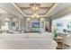 Open-concept living room with tray ceiling, built-ins, and view into other rooms and outdoor patio at 8059 Waterbend Trl, Sarasota, FL 34240