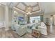 Bright living room with coffered ceiling, recessed lighting, stylish furnishings, and water view at 8059 Waterbend Trl, Sarasota, FL 34240