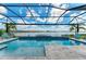 Sparkling pool with screened enclosure, lake views, and tropical landscaping at 8059 Waterbend Trl, Sarasota, FL 34240
