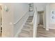 Carpeted staircase with white railing leading to upper level of the home at 8059 Waterbend Trl, Sarasota, FL 34240
