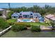 Gorgeous waterfront estate featuring a pool, spa, outdoor living space, and lush landscaping on a sunny day at 8155 Midnight Pass Rd, Sarasota, FL 34242