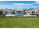Spacious backyard with an inviting pool, meticulous landscaping, and a grand home exterior, offering luxurious outdoor living at 8155 Midnight Pass Rd, Sarasota, FL 34242