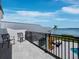 View from the balcony, showing outdoor seating, the waterway, and the metal roof of the home at 8155 Midnight Pass Rd, Sarasota, FL 34242