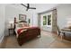 Cozy bedroom featuring hardwood floors, a four-poster bed, and ample natural light at 8155 Midnight Pass Rd, Sarasota, FL 34242