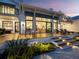 Elegant home featuring a spacious deck with outdoor seating, large windows, and manicured landscaping with exterior lighting at 8155 Midnight Pass Rd, Sarasota, FL 34242