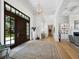 Grand foyer featuring hardwood floors, a chandelier, and an elegant front door with views to the beautifully landscaped front yard at 8155 Midnight Pass Rd, Sarasota, FL 34242