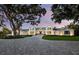 Elegant home with a long driveway and beautiful landscaping, featuring a gated entrance and lush greenery at 8155 Midnight Pass Rd, Sarasota, FL 34242