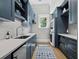 Laundry room with stainless steel appliances, blue cabinets, hardwood floors, and geometric rug at 8155 Midnight Pass Rd, Sarasota, FL 34242