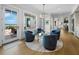 Cozy living area with plush blue seating, a modern chandelier, and scenic views of the water front at 8155 Midnight Pass Rd, Sarasota, FL 34242