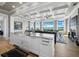 Elegant living area with coffered ceilings, an island sink, and stunning water views through large windows at 8155 Midnight Pass Rd, Sarasota, FL 34242