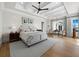 Serene main bedroom featuring a tray ceiling, neutral decor, and sitting area with water view at 8155 Midnight Pass Rd, Sarasota, FL 34242