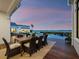 Outdoor dining on a covered patio offers sunset water views, creating an ideal place to gather and share a meal at 8155 Midnight Pass Rd, Sarasota, FL 34242