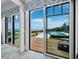 Open sliding glass doors reveal backyard pool, patio, and landscape with waterfront views beyond at 8155 Midnight Pass Rd, Sarasota, FL 34242