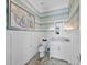 Chic powder room with a granite countertop, custom sink, wainscoting, and unique wallpaper at 8155 Midnight Pass Rd, Sarasota, FL 34242