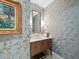 Elegant powder room with blue wallpaper, framed art, and wooden vanity at 8155 Midnight Pass Rd, Sarasota, FL 34242