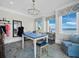 Bright sewing room with water view features a large table, chandelier, and stylish blue accents at 8155 Midnight Pass Rd, Sarasota, FL 34242