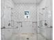 Luxurious marble shower with dual shower heads, mosaic tile, and a window for natural light at 8155 Midnight Pass Rd, Sarasota, FL 34242