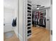 Large walk-in closet with hardwood floors and custom shelves for shoes and folded clothing at 8155 Midnight Pass Rd, Sarasota, FL 34242
