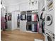 Large walk-in closet with custom shelving, hanging racks, chandelier and integrated washer and dryer at 8155 Midnight Pass Rd, Sarasota, FL 34242