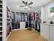 Bright walk-in closet with hardwood floors, custom shelving, and a center island with drawers at 8155 Midnight Pass Rd, Sarasota, FL 34242