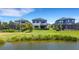 Beautiful backyard view of the home with a pond, lush greenery, and manicured lawn at 8355 Velda Trl, Sarasota, FL 34241